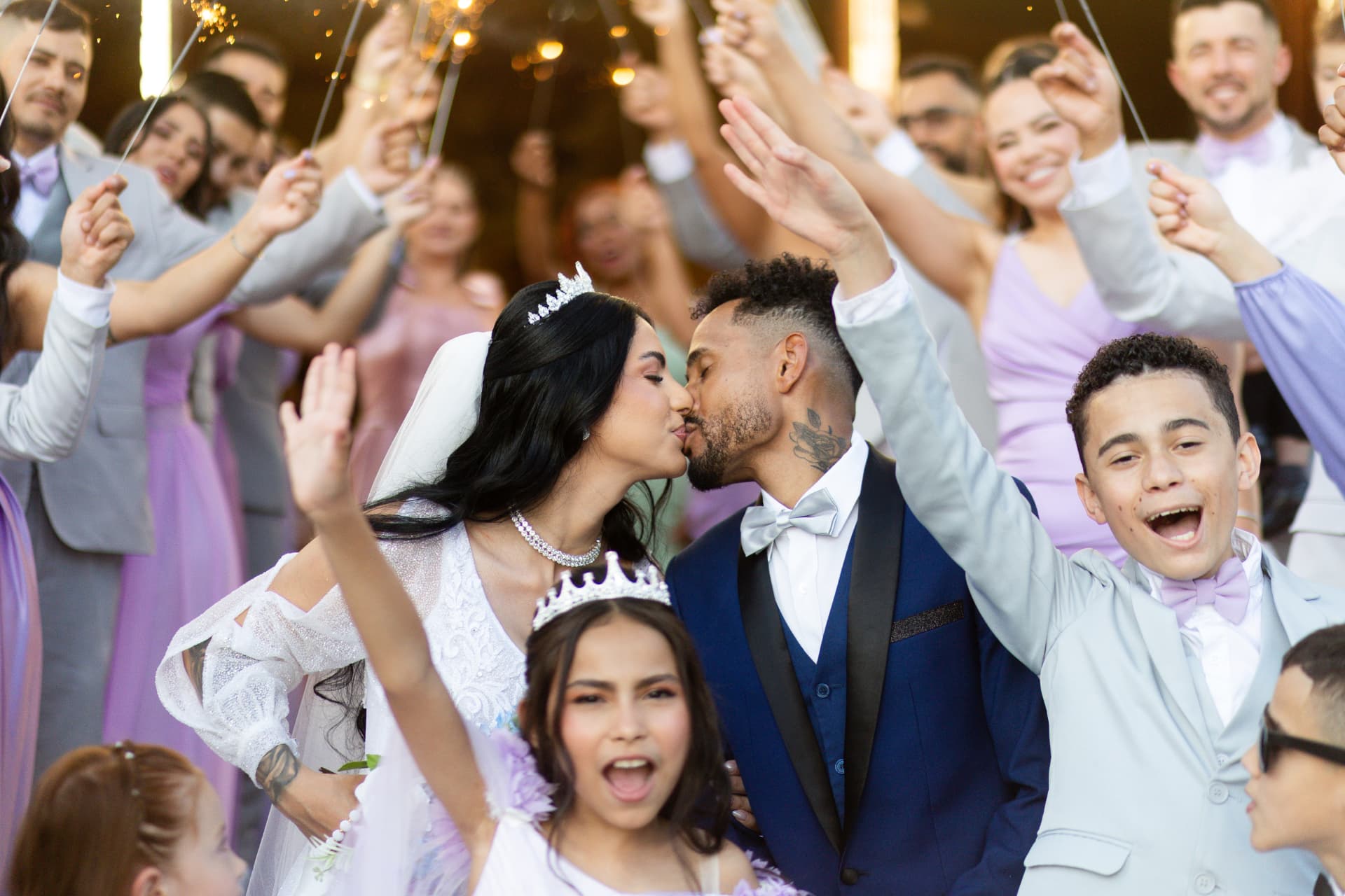 Beijo dos noivos entre convidados com sparklers