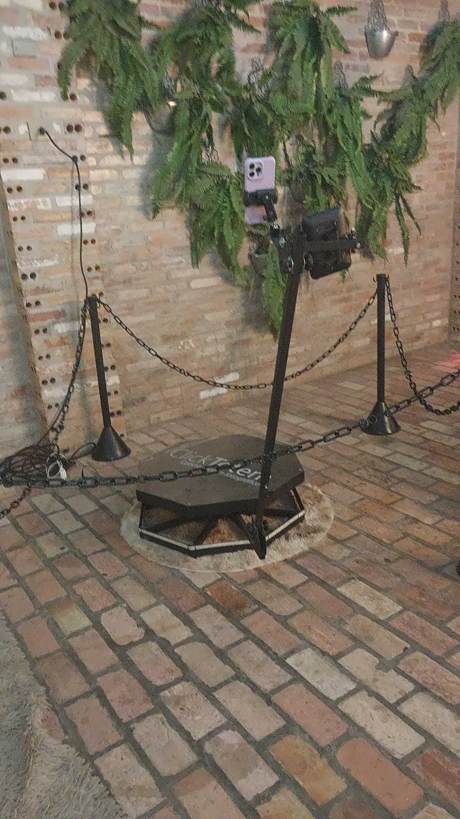 Plataforma 360° Click Totem montada em evento com braço giratório e cordão de isolamento