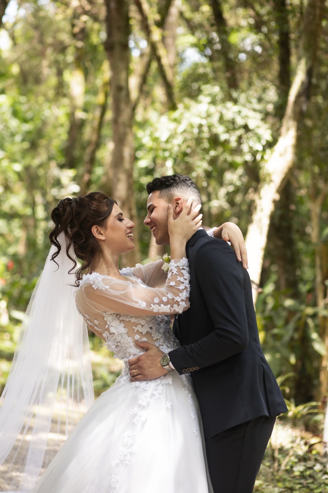 Noiva e noivo se abraçando em casamento ao ar livre