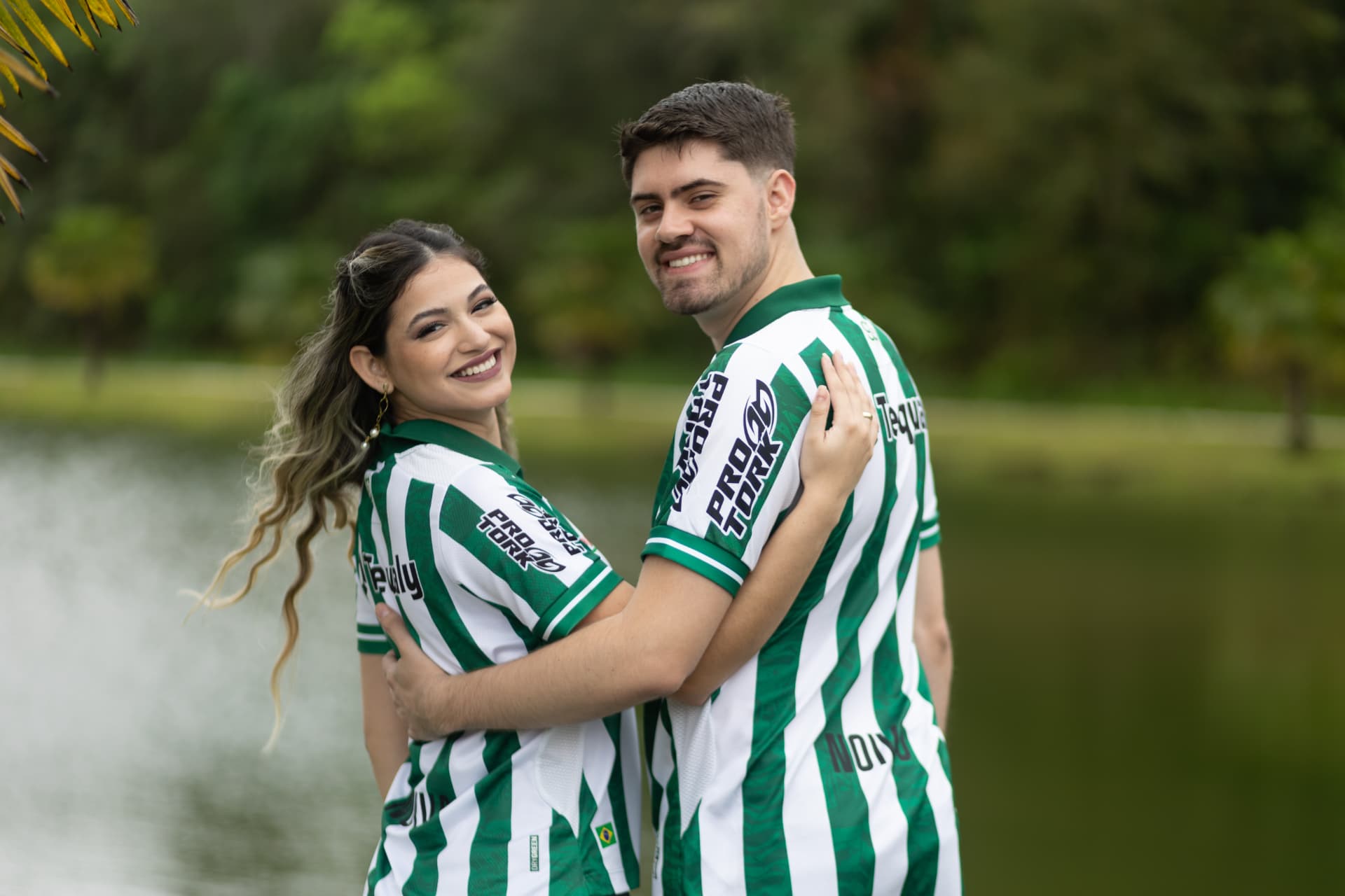 Casal com camisas de time em ensaio no parque